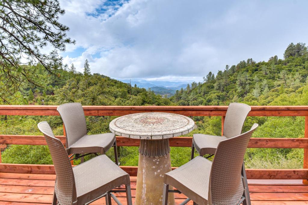 a table and chairs on a deck with a view at Mtn-View Coulter Escape w/ Rustic Tree Lookout in Coulterville