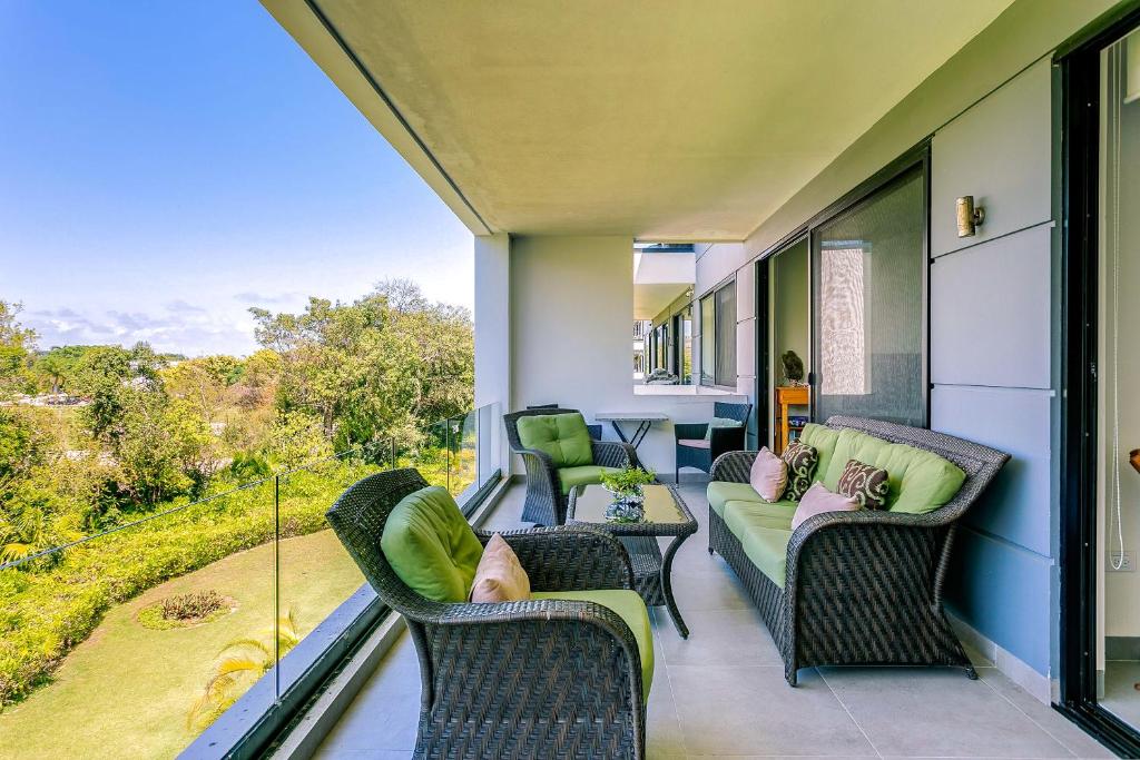 eine abgeschirmte Veranda mit Stühlen und einem Tisch mit Aussicht in der Unterkunft Golfers' Paradise at Nick Price Residences! in Playa del Carmen