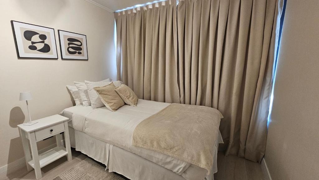 Un dormitorio blanco con una cama y una ventana. en LUUM by Norus, en Santiago