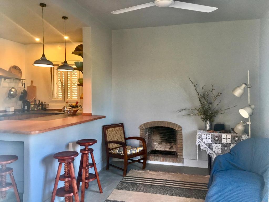 a kitchen and a living room with a fireplace at Charming Country House in Poço do Álamo