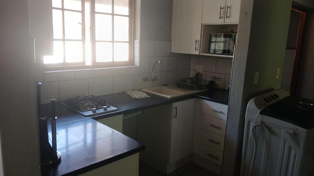 a kitchen with a sink and a counter top at Dee in Sandton
