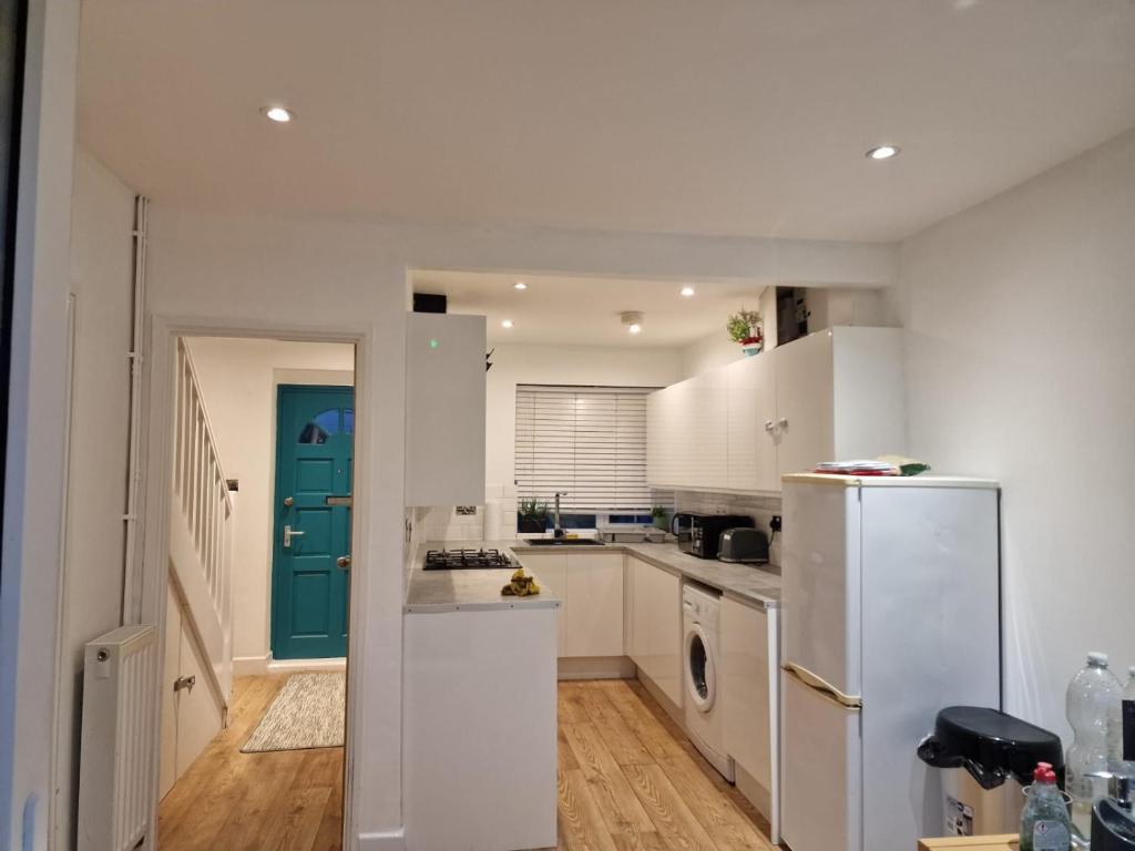 a kitchen with a white refrigerator and a blue door at Jugno Home in Oxford