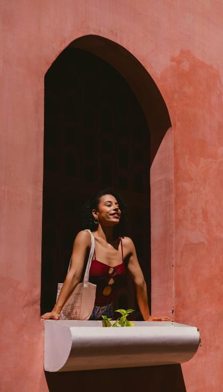 a woman sitting in a window of a building at Casa Amate 61 - Mérida centro in Mérida