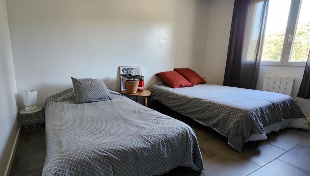 a bedroom with two beds and a window at La Solentina in Reynès
