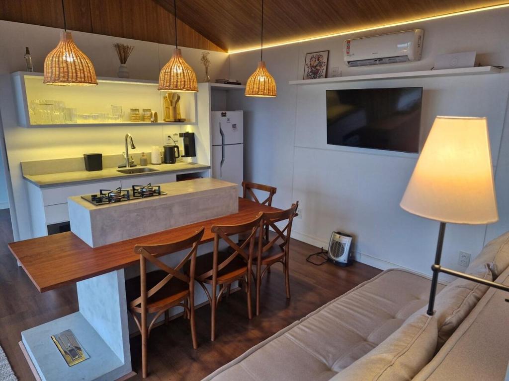 ランショ・ケイマードにあるTiny House em Taquaras, Rancho Queimadoのキッチンとテーブルとソファのあるリビングルーム