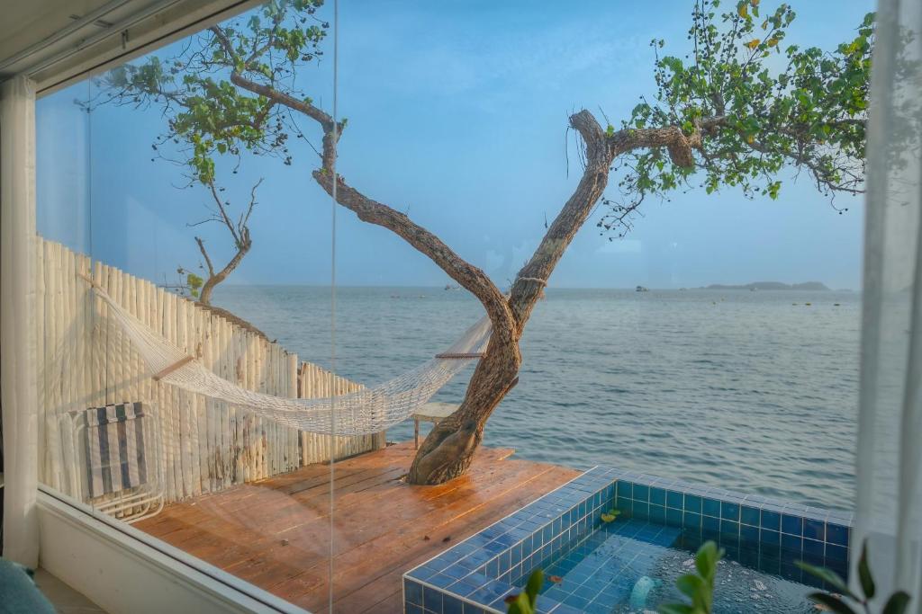 a hammock on a porch overlooking the water at White in Ko Larn