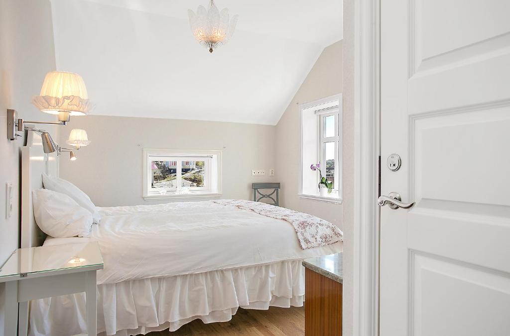 a white bedroom with a bed and a window at Lotshotellet in Käringön