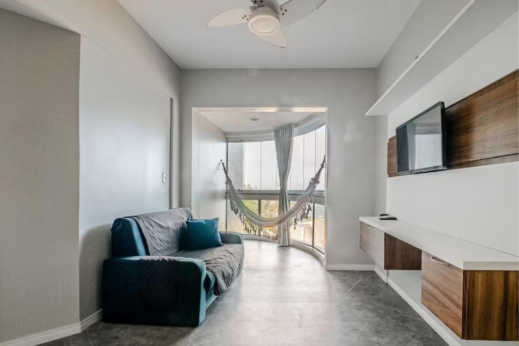 een woonkamer met een bank en een groot raam bij Lindo Vista Mar, Praia do Buracão - Rio Vermelho in Salvador