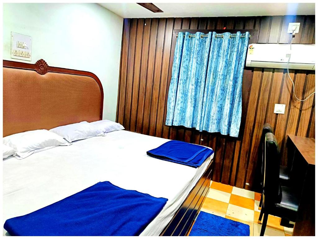 a bedroom with a bed and a wooden wall at Hotel P-V-R 50 Meters Only From Railway Station With Free Internet Services in Bhubaneshwar