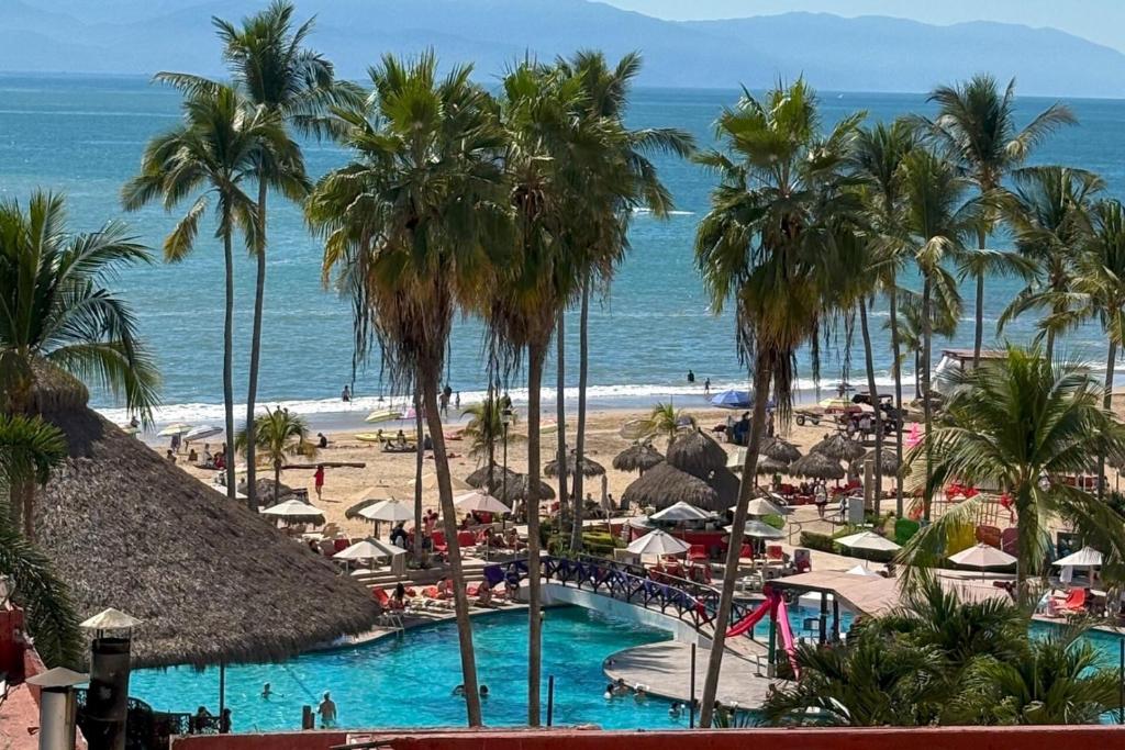 vista su una spiaggia con palme e piscina di Spacious, with access to the pool and the beach! a Puerto Vallarta
