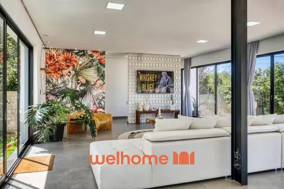 a living room with a white couch and a wall of windows at Suite em Tibau do Sul proxima a praia das Minas in Pipa