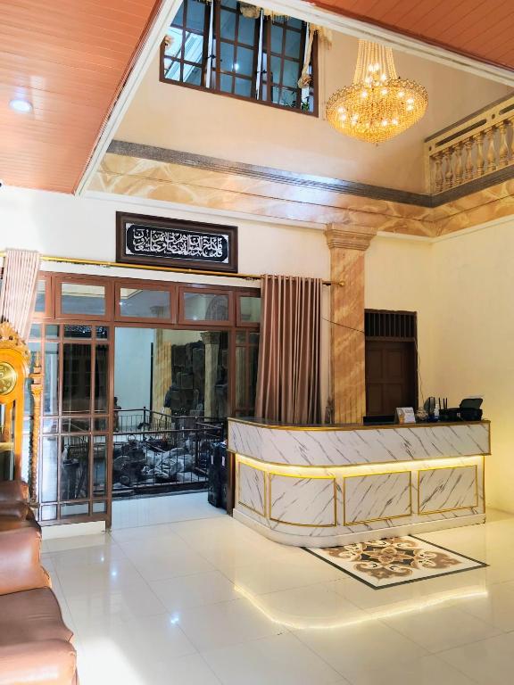 a lobby of a hotel with a chandelier at Among Rogo Syariah in Yogyakarta