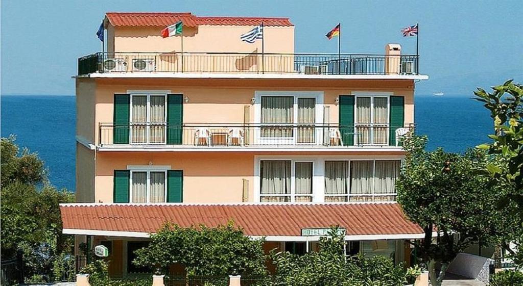 a tall building with flags on top of it at Hotel Perama in Perama