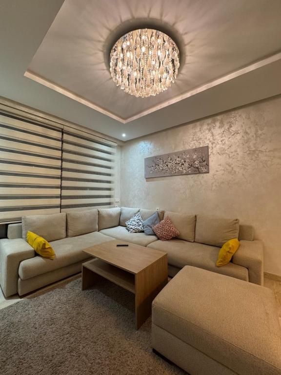 a living room with a couch and a chandelier at Perfect getaway pool, comfort and proximity in Agadir