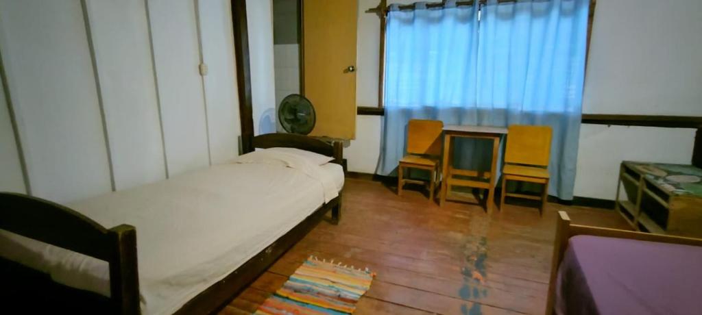 una camera da letto con un letto, un tavolo e delle sedie di Dondelachata a Máncora