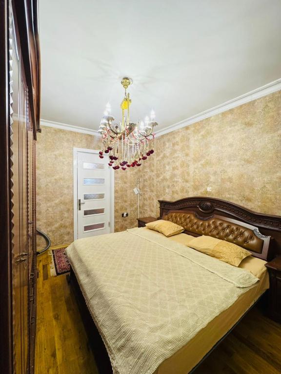 a bedroom with a large bed and a chandelier at Priority Ganja in Ganja