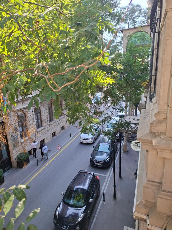 a street with cars parked on the side of the road at Hôtel Jeanne d'Arc Central in Baku