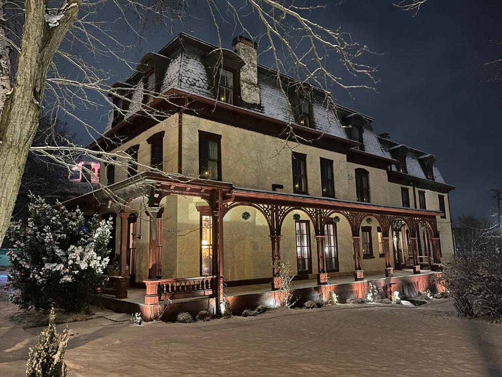 an old house with a large building at night at Gould Swaby Mansion in Seneca Falls