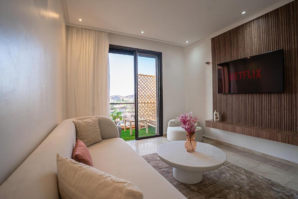 un salon avec un canapé et une télévision dans l'établissement œil de la vallée, à Marrakech