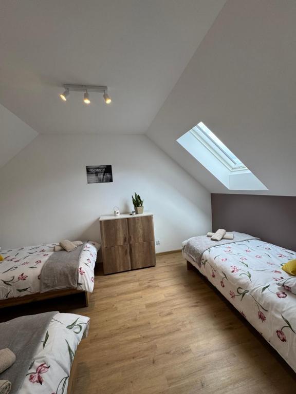 a attic bedroom with two beds and a skylight at Roztoczański Raj in Rogóźno