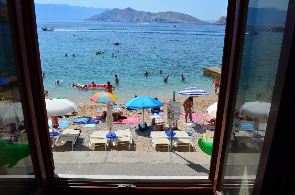 a view of a beach with people in the water at Apartment Sandi in Baška