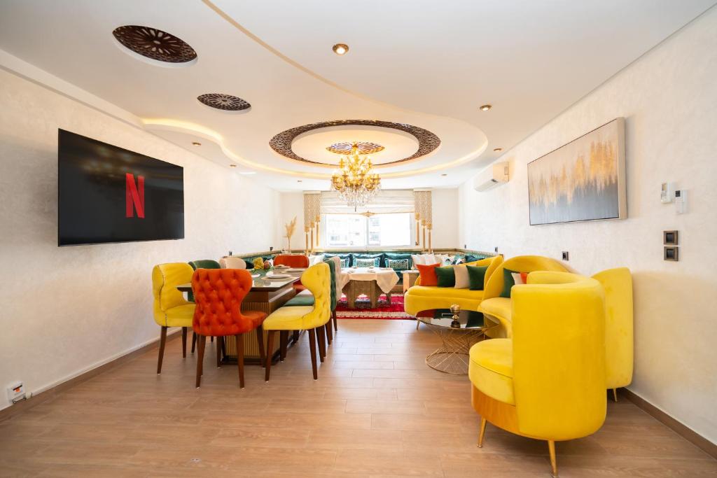 ein Esszimmer mit gelben Stühlen und einem Esstisch in der Unterkunft L'étoile de Tanger - Jacuzzi - Proche plage & Corniche - Appartement Chic et Moderne - Jusqu'à 8 personnes - AC, WIFI, IPTV in Tangier