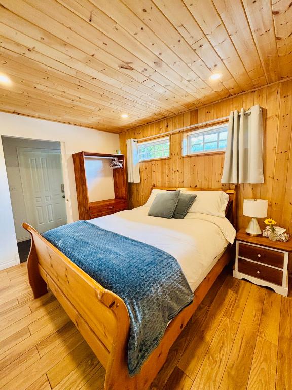a bedroom with a large bed with a wooden ceiling at Sunshine Bungalow in Salmon Arm