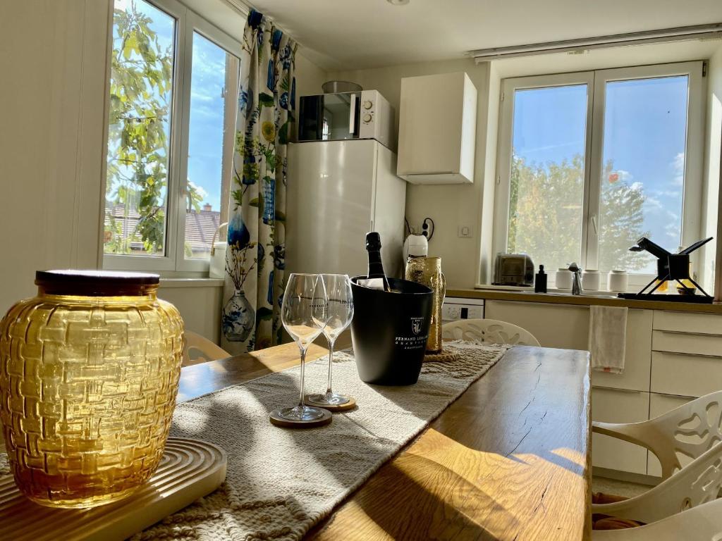 una cocina con una mesa con dos copas de vino. en Happy, en Cernay-lès-Reims