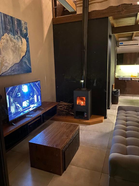 a living room with a tv and a fireplace at Loft de Montaña in Río Ceballos