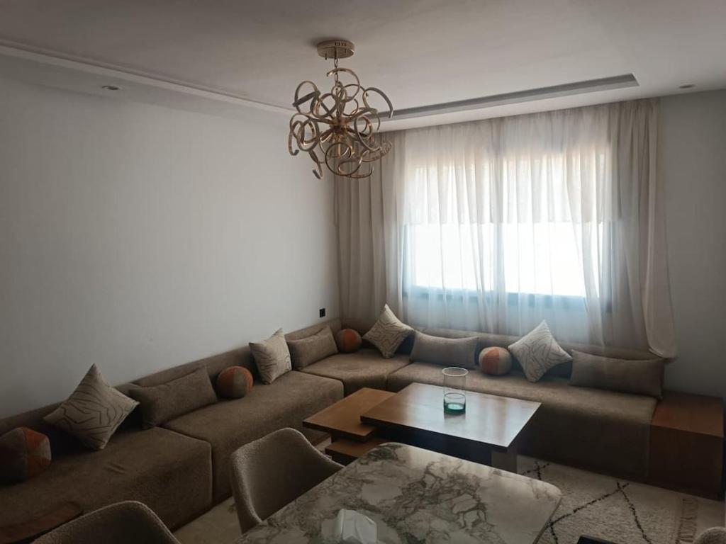 salon z kanapą i stołem w obiekcie Élégant appartement moderne au cœur d Agadir Bay w mieście Agadir