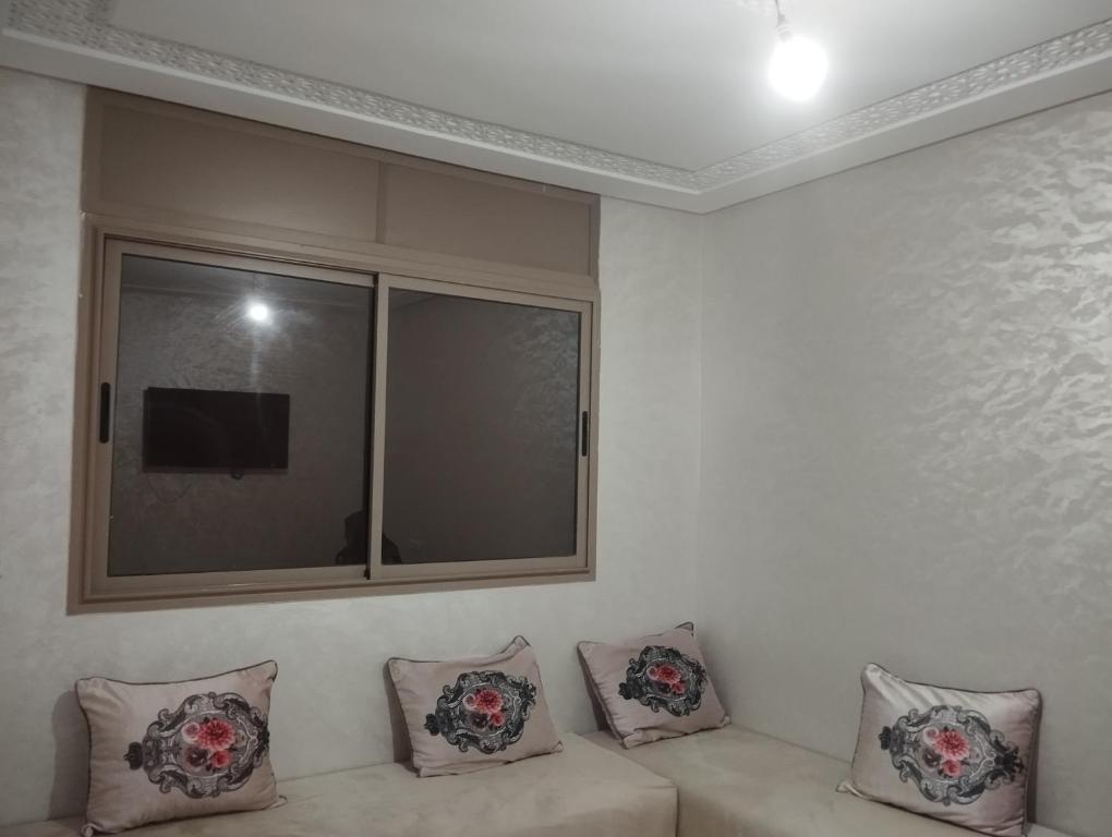 a white couch with three pillows and a window at Sara guest house in Agadir