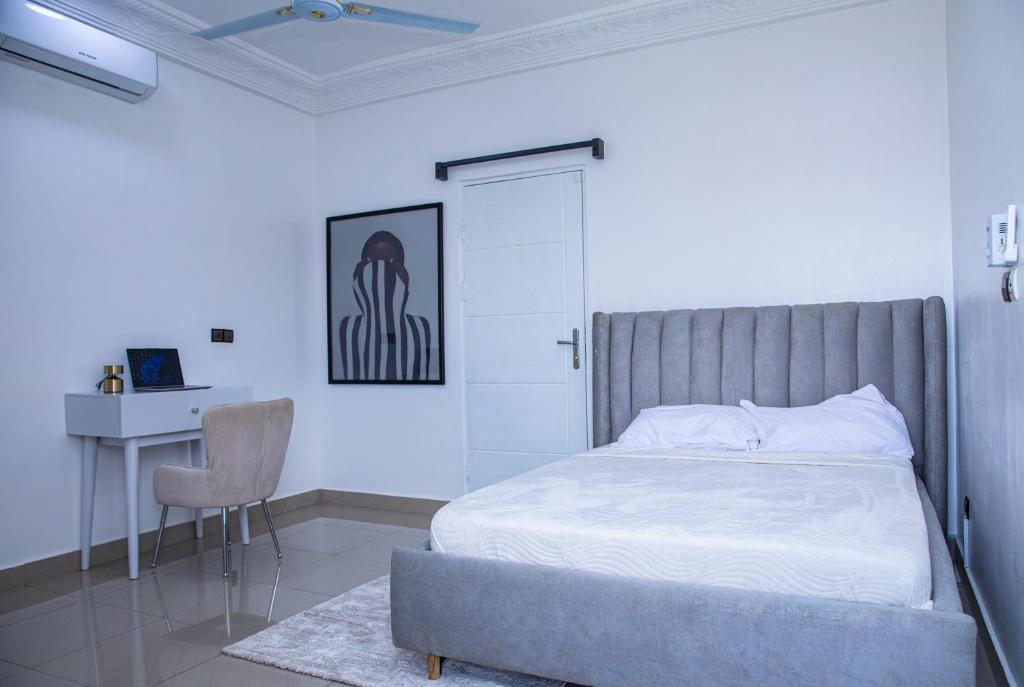 Un dormitorio con una cama, un escritorio y una silla. en Calm loft - Fidjrosse 5min plage, en Cotonou
