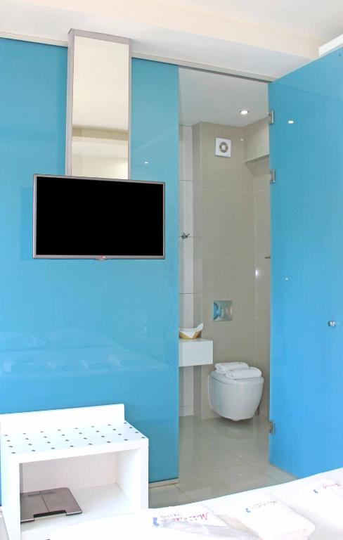 a bathroom with a toilet and a tv on a wall at Macedon in Limenas