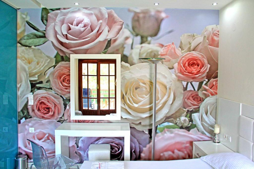 a bedroom with a mural of roses and a mirror at Macedon in Limenas