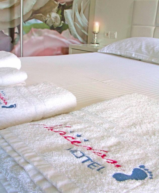 a bed with towels on it with a white bedspread at Macedon in Limenas