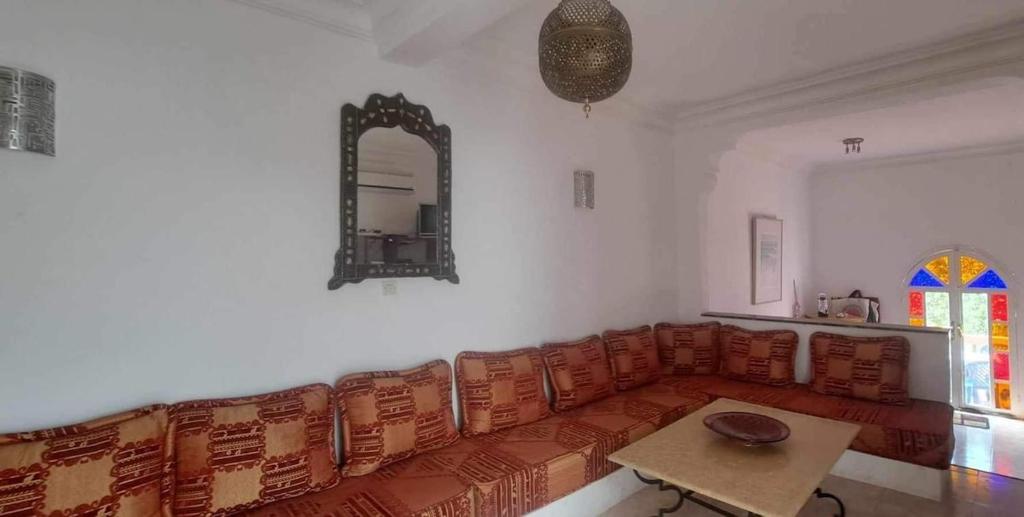 un salon avec un canapé et une table dans l'établissement Riad Diaz Taghazout, à Ikouzza