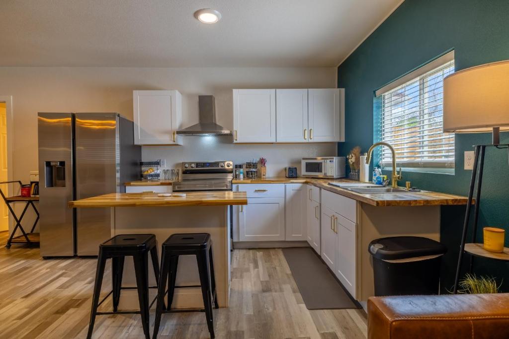 a kitchen with white cabinets and a counter with stools at Downtown Garden Escape in Casper