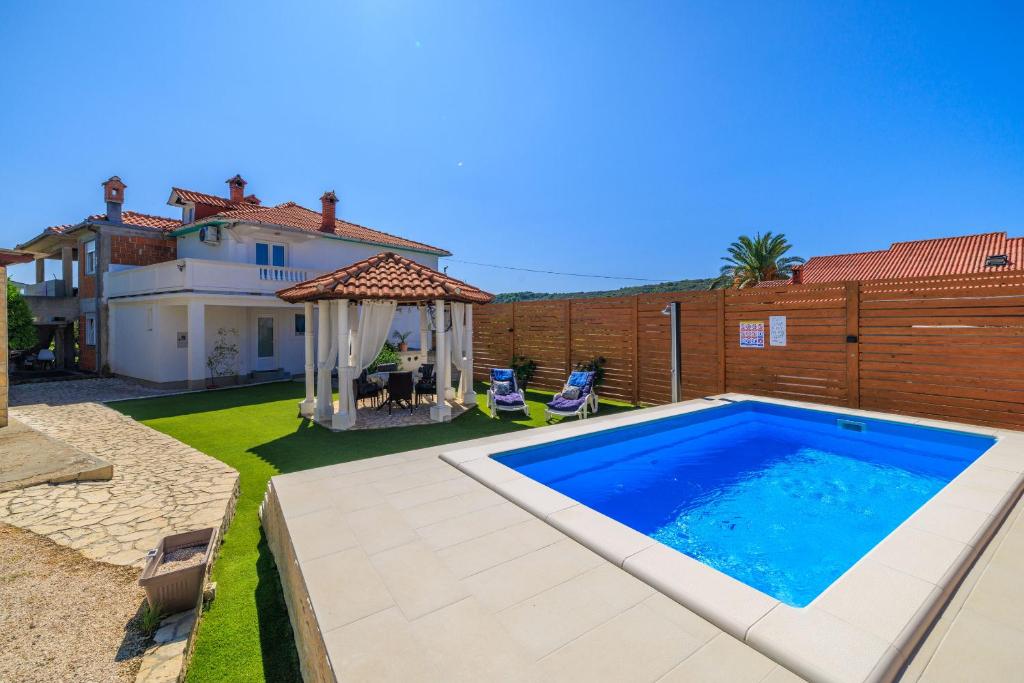 a backyard with a swimming pool and a house at Apartment Pavilion in Kampor