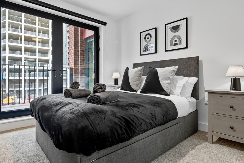 リバプールにあるCentral Liverpool Luxury 2BR w Balcony & 2 Bathsの大きなベッドと大きな窓のある寝室