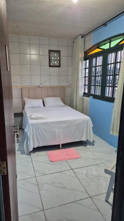une chambre avec un lit blanc et un tapis rouge dans l'établissement Pousada Top Mix, à Florianópolis