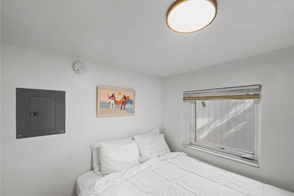 a white bedroom with a bed and a window at Sea Haven Motel Unit .5 in Rockaway Beach