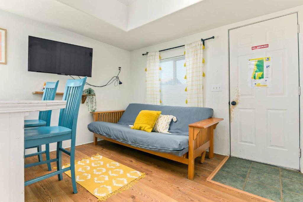 a living room with a blue couch and a tv at Sea Haven Motel Unit .7 in Rockaway Beach