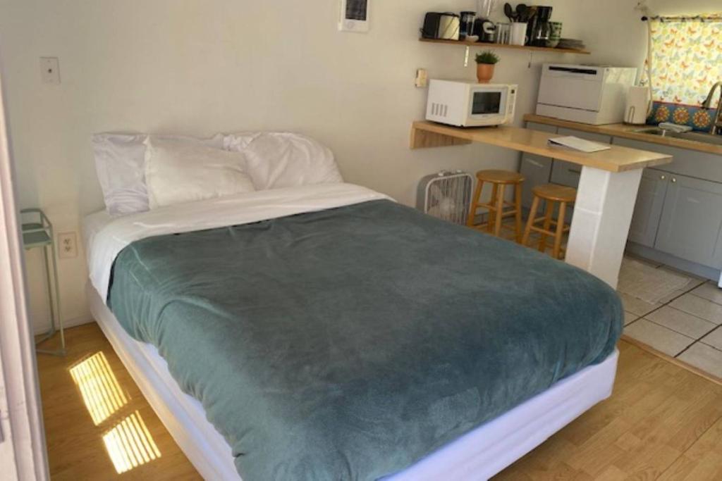 a bedroom with a large bed and a kitchen at Sea Haven Motel Unit #4 in Rockaway Beach