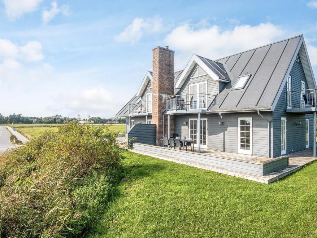 a blue house with a porch and a deck at 5 star holiday home in Rømø in Sønderby