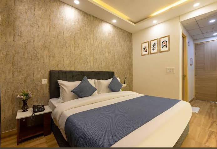 a bedroom with a large bed with blue pillows at Elite stay 4 in Greater Noida