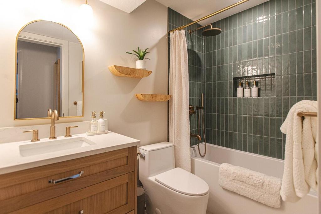 ノースバンクーバーにあるModern Lynn Valley Retreat with Mountain and City Viewsの洗面台、トイレ、シャワー付きのバスルーム