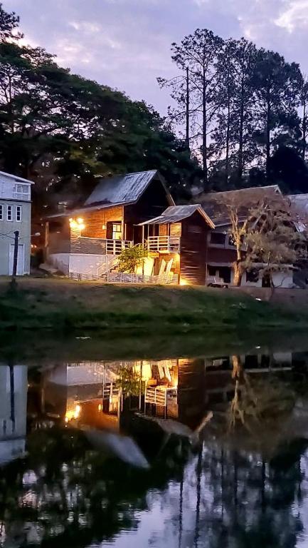 a house sitting next to a body of water at Chale Recanto do Lago in Itu