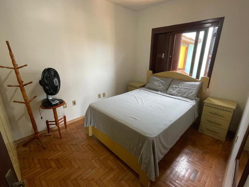 ein Schlafzimmer mit einem Bett und einem Fenster in der Unterkunft Casa de veraneio 2 dormitórios in Torres