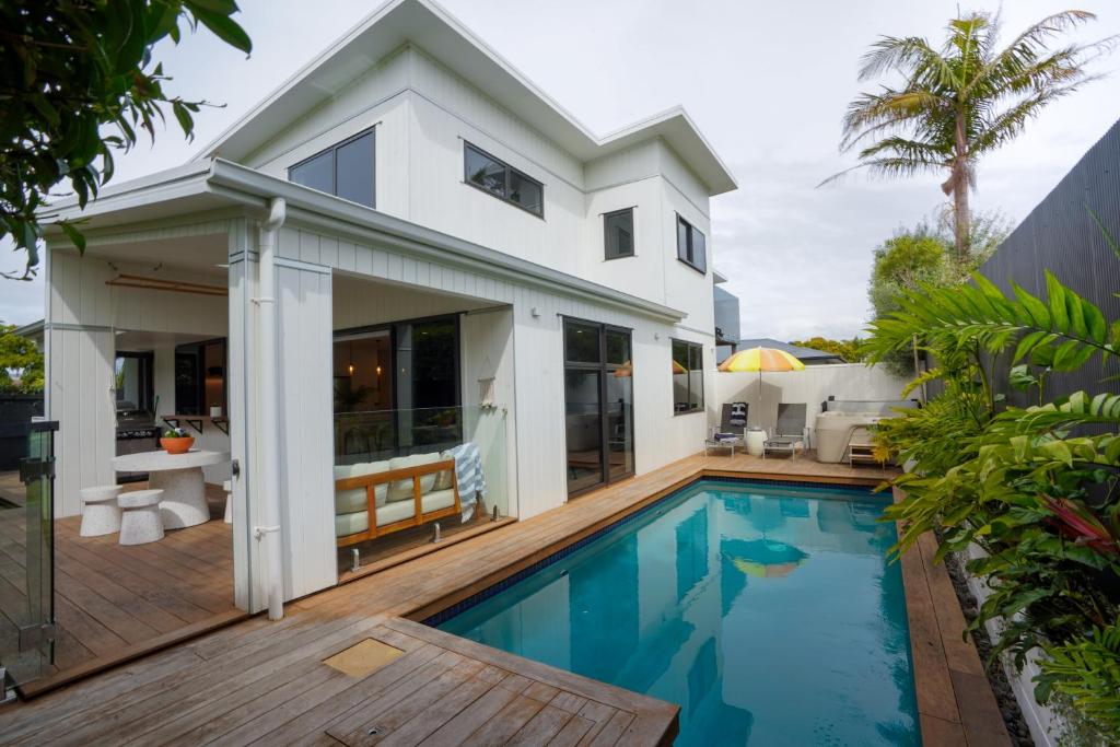 a home with a swimming pool and a house at The Mount Retreat By Aotearoa Escapes in Mount Maunganui
