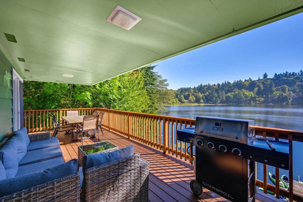 レイシーにあるPrivate Dock and Fire Pit Lakefront Gem in Olympiaのグリルと家具が備わった網戸付きポーチ
